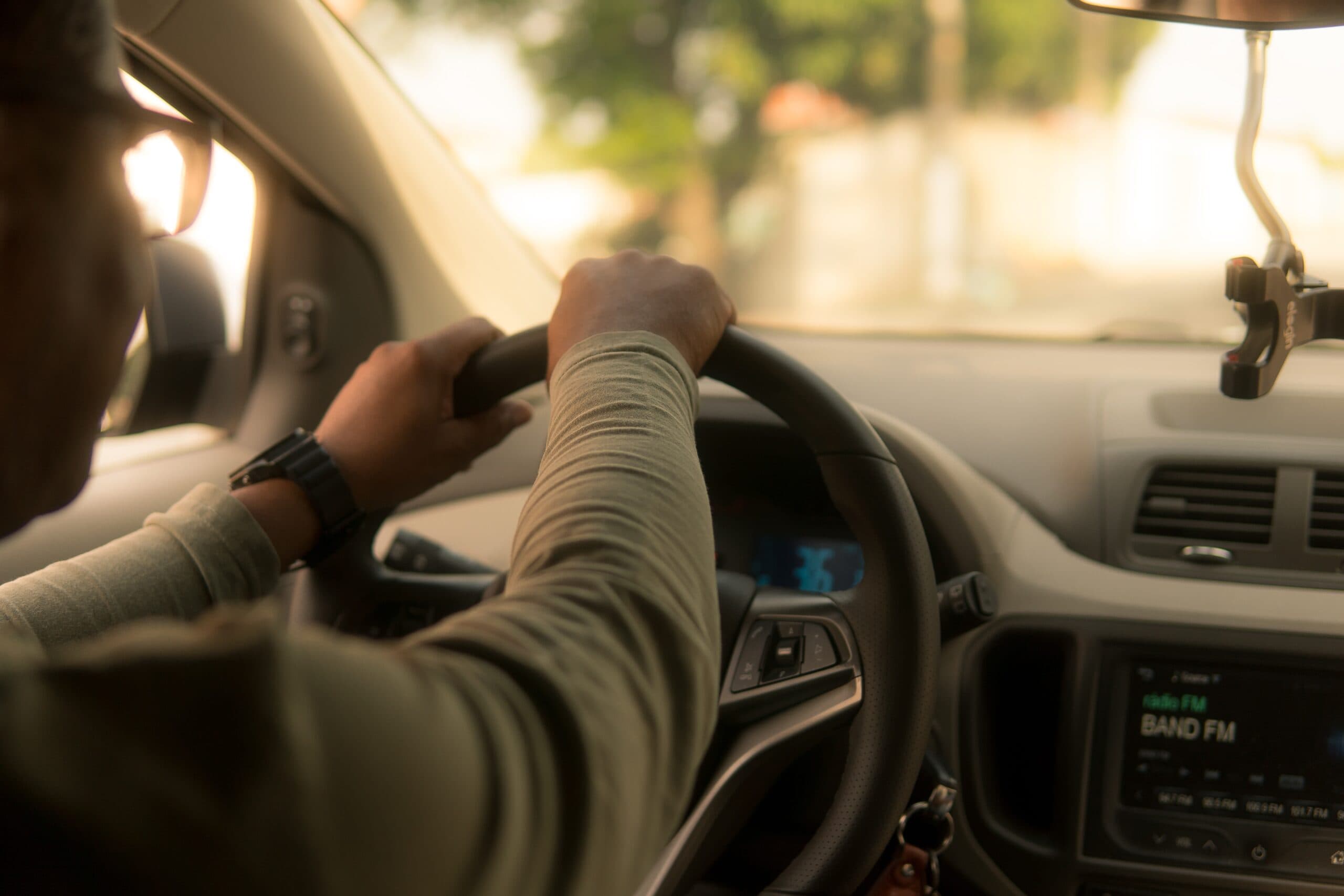 Persona al volante, mani sullo sterzo di un'auto